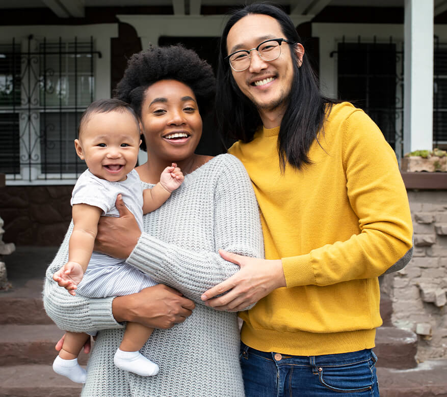 happy family with baby in front of house